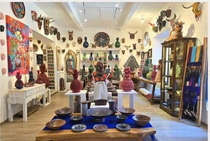 Interior de la galería con muro de máscaras artesanales